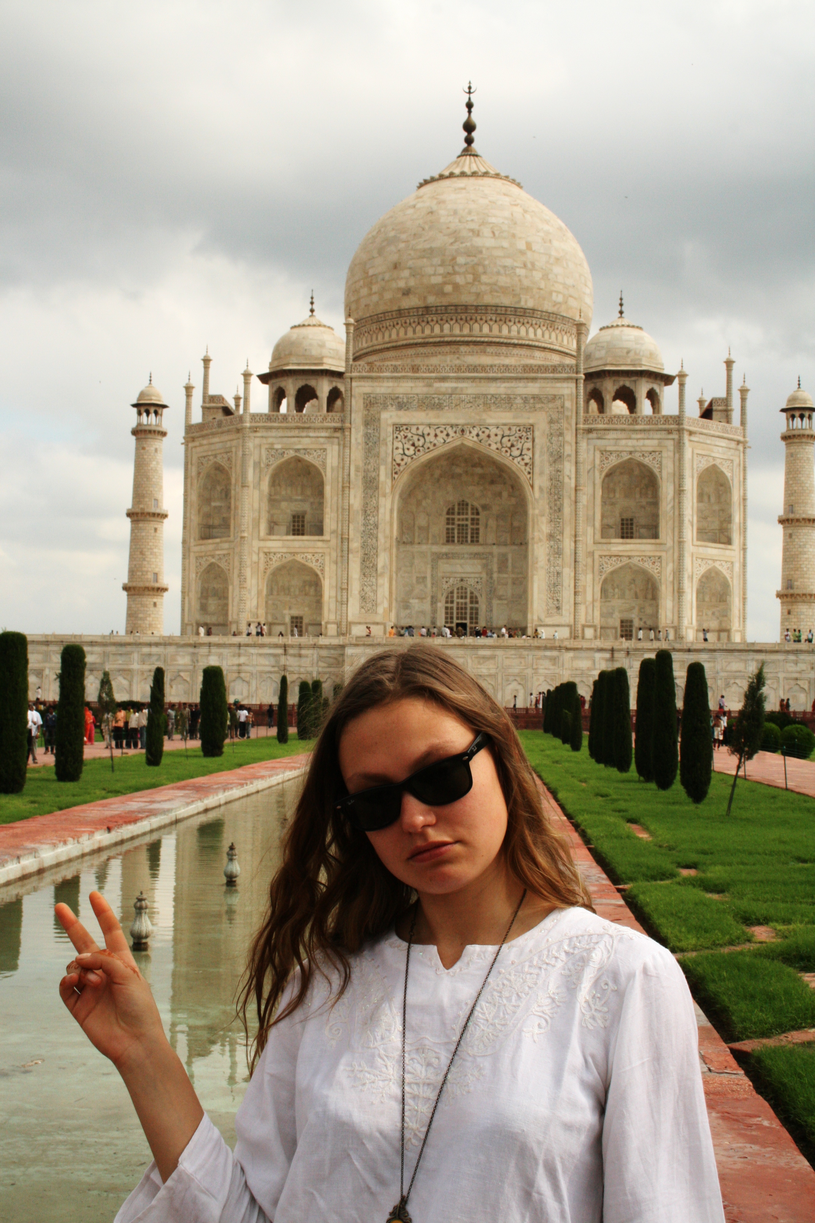 Claire in front oj Taj Mahal with peace symbol. Hued purple and yellow