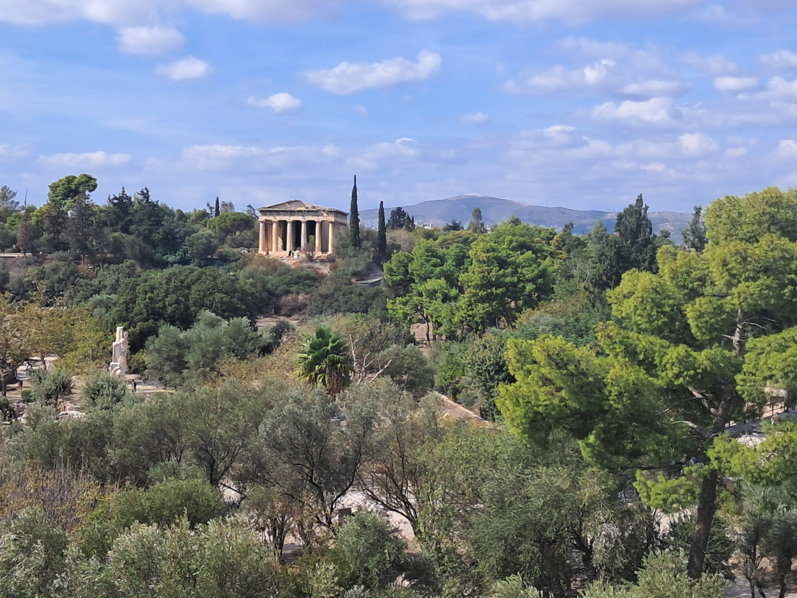 Wide view of Athens with ancient temple ruins and mountains behind