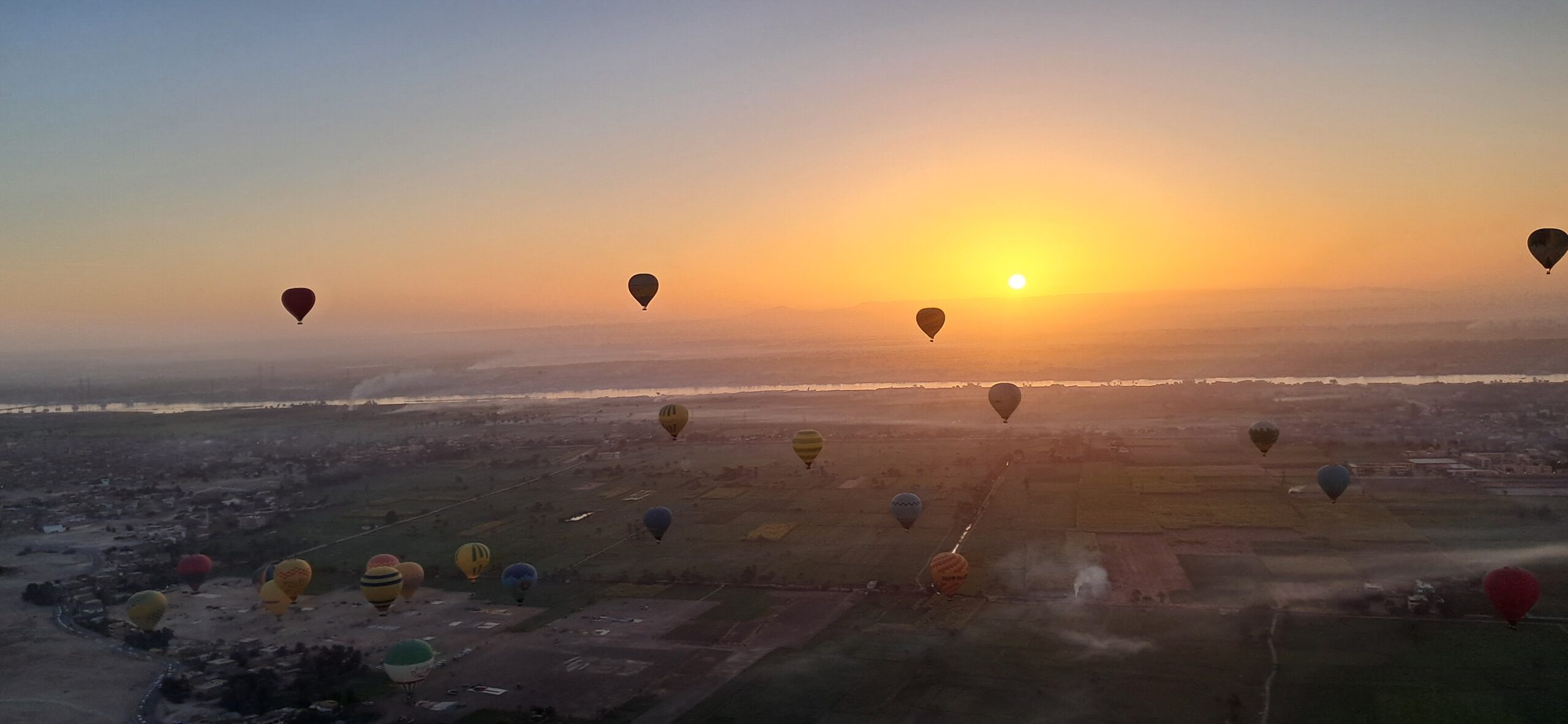 Hot air balloons rising at sunrise over Luxor