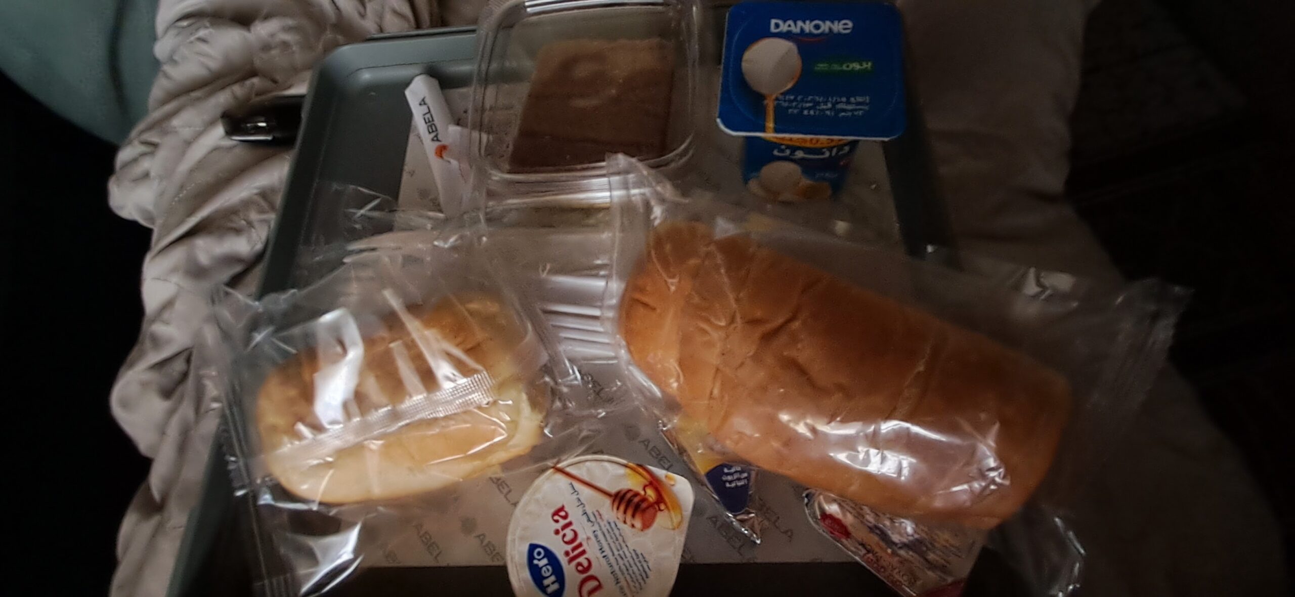 The sleeper train breakfast of bread rolls, a croissant and a dairy yogurt, none of it vegan
