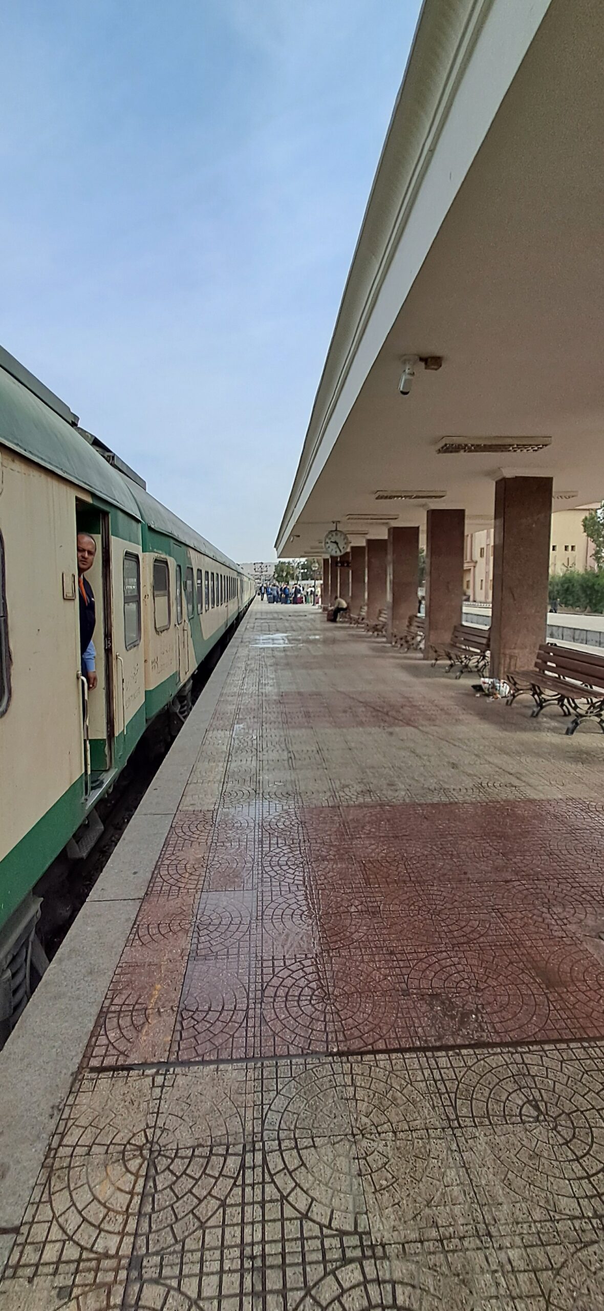 The green and cream Egyptian sleeper train waiting at the platform on the Cairo to Aswan route
