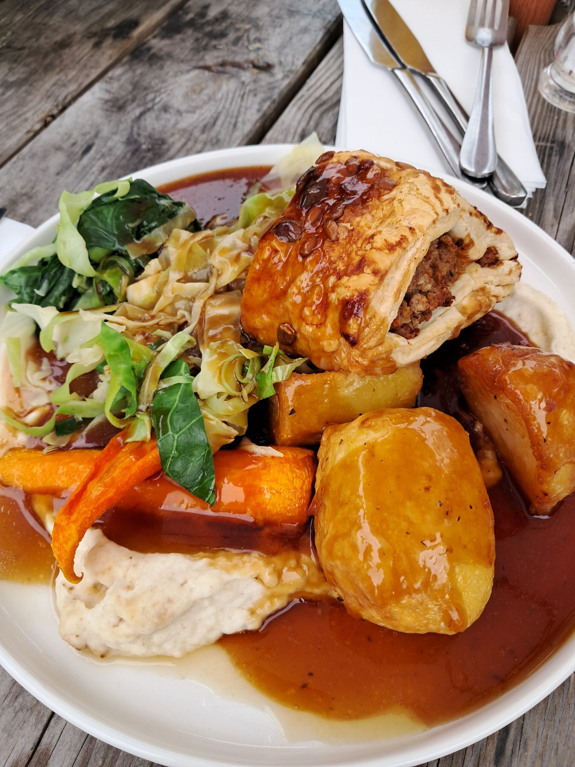 A vegan Sunday roast with roast potatoes, greens and gravy