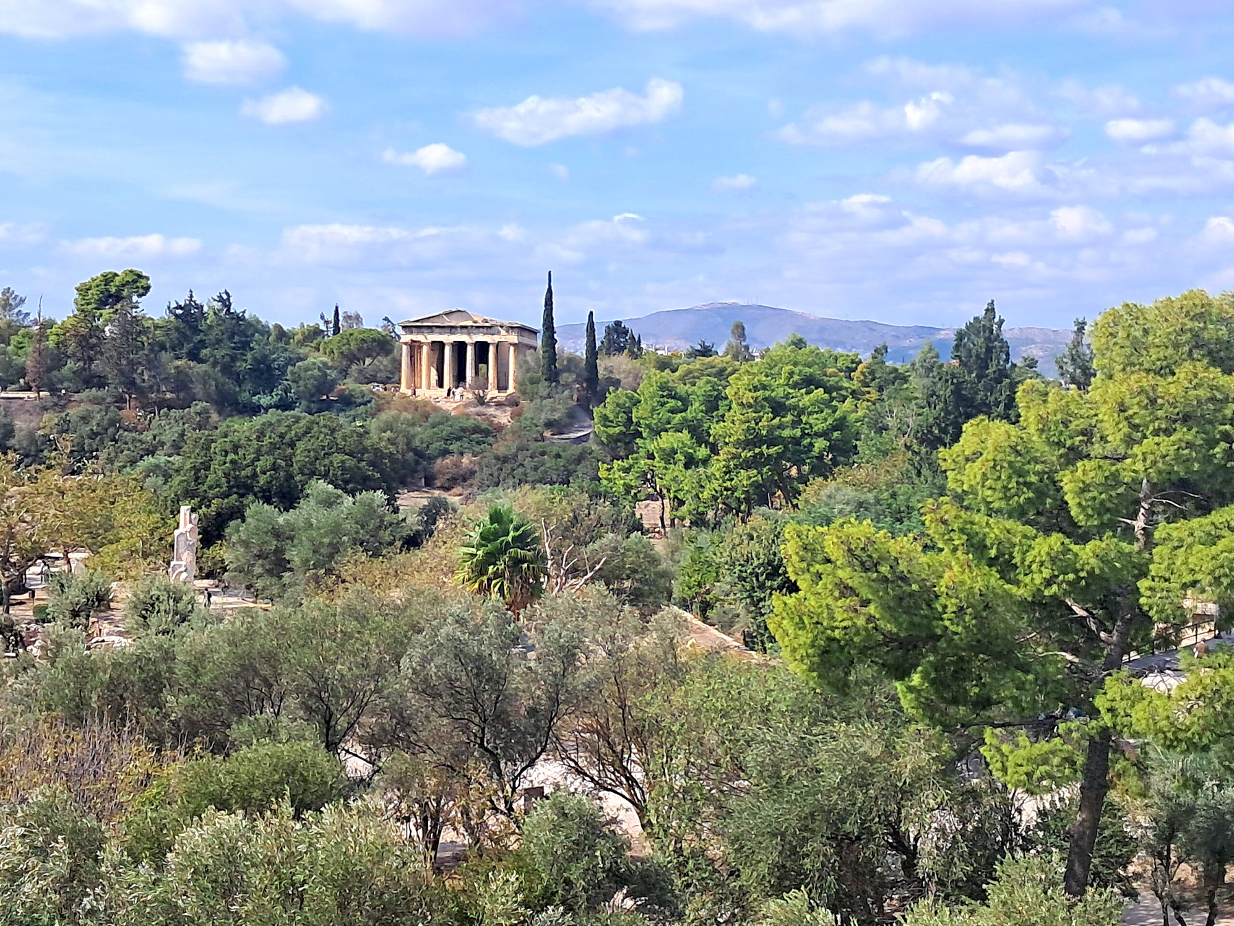 Wide view of Athens with ancient temple ruins and mountains behind