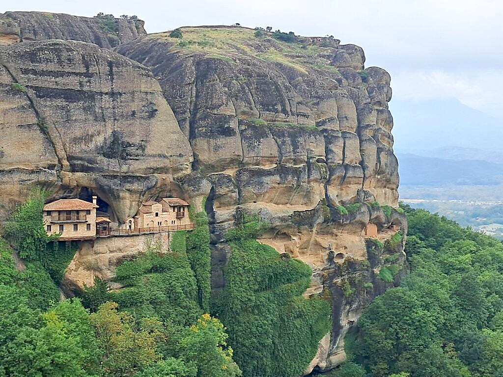 Hermit cave monastery built into the rock face at Meteora, visible from the guided hiking trail near Kalambaka