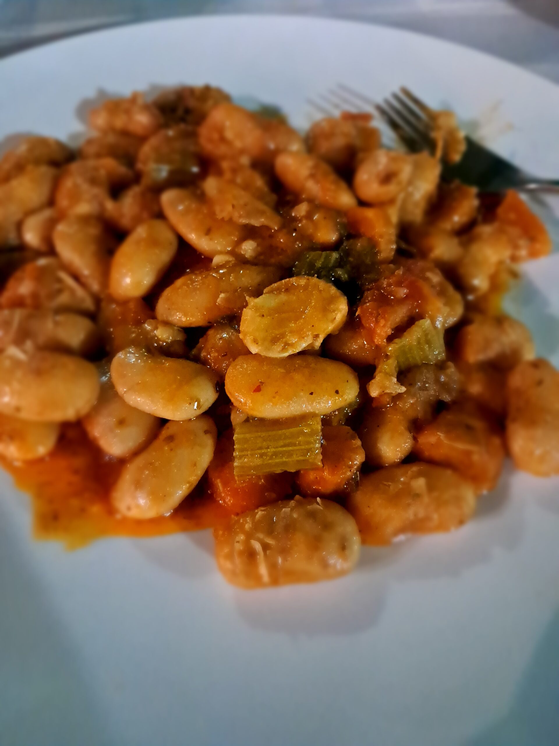 A plate of Greek gigantes, giant beans in tomato sauce, naturally vegan