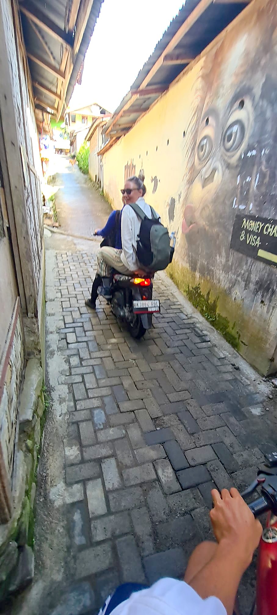 Claire riding pillion on a motorbike arriving near Bukit Lawang