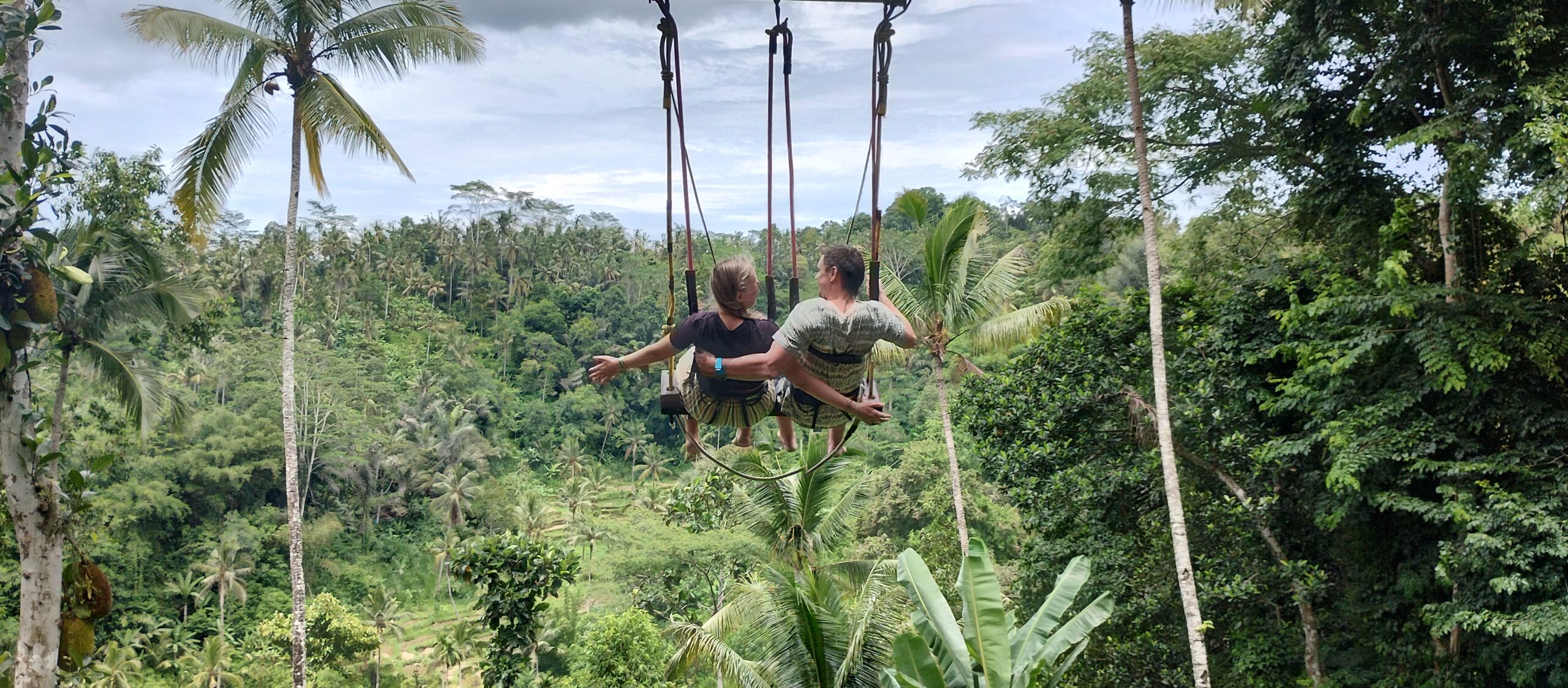 Two people on a swing over the jungle valley near Ubud, Bali